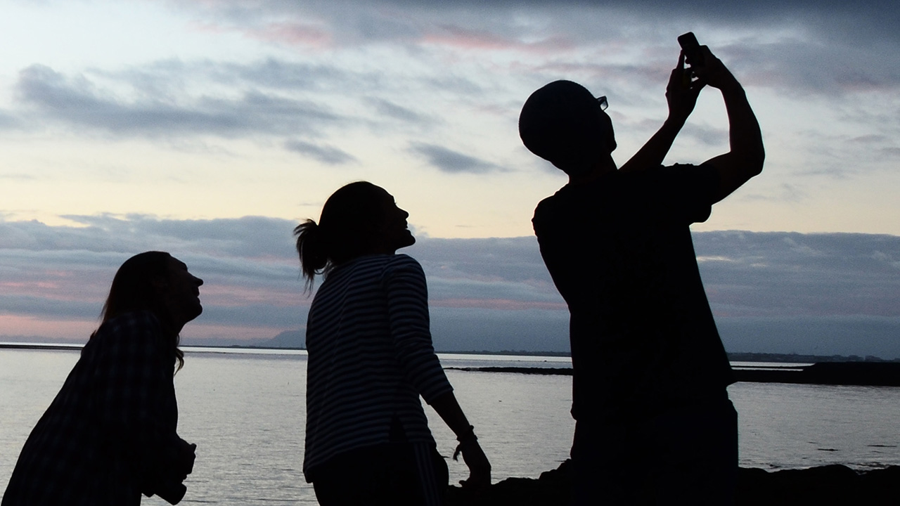 silhouette photo of students taking a video selfie