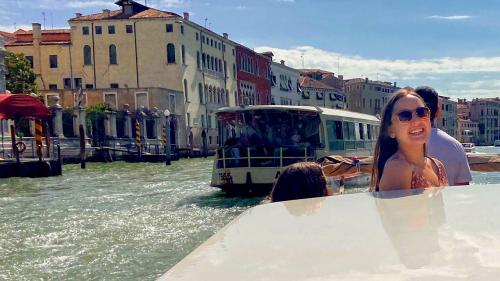 Photo of a student, smiling and on a boat in Venice.